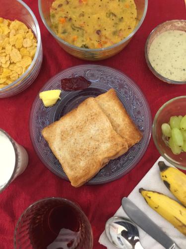 a table topped with a plate with a piece of toast at Locul Uptown - Near Bangalore Palace Grounds in Bengaluru