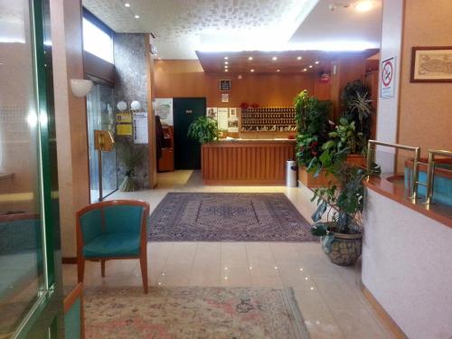 a lobby of a store with a chair and a waiting room at Hotel Cristallo in Udine