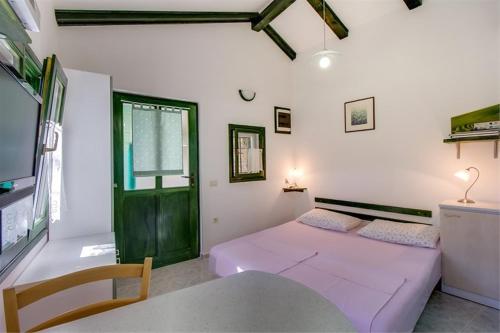ein Wohnzimmer mit einem lila Sofa und einer grünen Tür in der Unterkunft Apartment Julia in Veli Lošinj