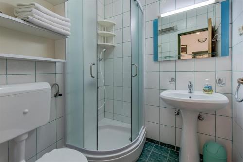 ein Bad mit einer Dusche, einem Waschbecken und einem WC in der Unterkunft Apartment Julia in Veli Lošinj