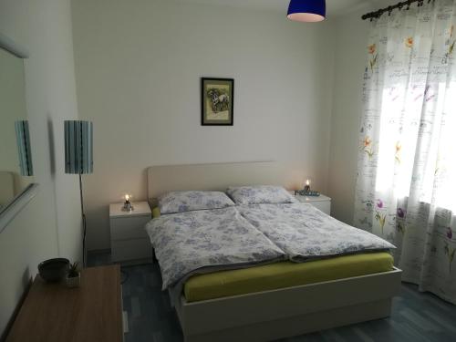 a bedroom with a bed and two night stands at Apartments Sandra in Poreč