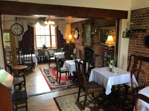 un restaurante con mesas y sillas y una pared de ladrillo en Englands Rose, en Thame
