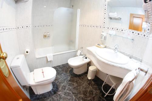 La salle de bains blanche est pourvue d'un lavabo et de toilettes. dans l'établissement Maria de Luna, à Segorbe