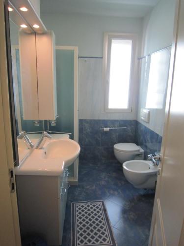 uma casa de banho com 2 lavatórios, um WC e uma janela em Hotel Astra em Cattolica