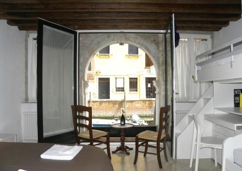 a room with a table and chairs and a window at La Coccola in Venice