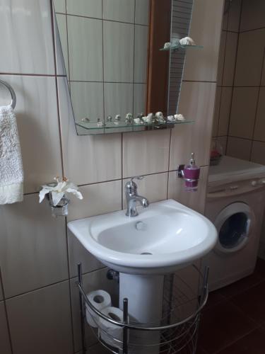a bathroom with a sink and a washing machine at Amalia's Apartments in Kissamos