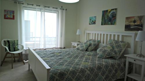 - une chambre avec un lit et une grande fenêtre dans l'établissement Santa Luzia Dream, à Santa Luzia