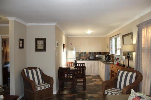 a kitchen with two chairs and a table in it at Welbedacht Estate Self catering Accommodation in Port Elizabeth
