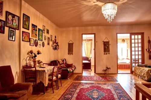 a living room with a table and a chandelier at Nitsa Guest House in Gori
