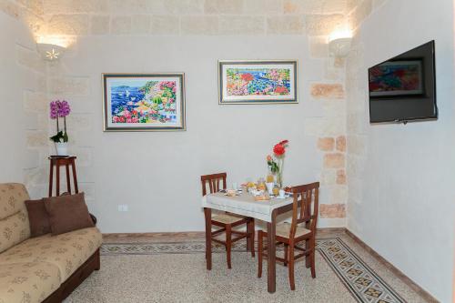 ein Wohnzimmer mit einem Tisch und einem Sofa in der Unterkunft Torres Suite in Polignano a Mare
