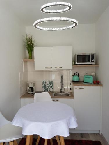 a kitchen with a white table and a chandelier at Gästezimmer Resi in Illmitz
