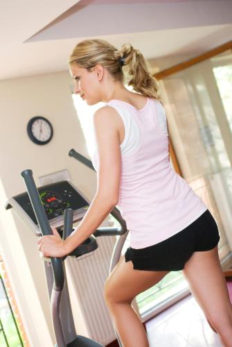 a woman on a treadmill in a gym at Hotel Azur Siofok in Siófok