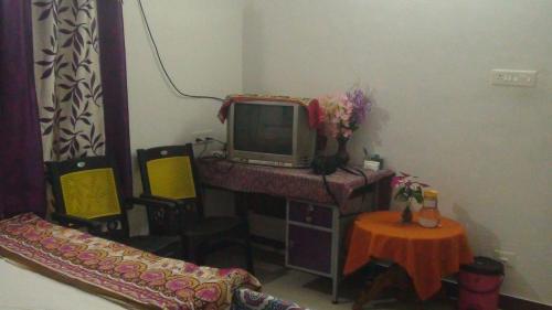 a room with a desk with a tv and a table at Takashi Homestay North Paravur Near Muziris in North Paravur