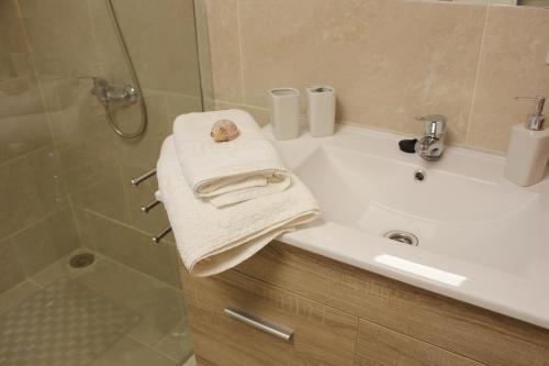 a bathroom with a sink and a shower and a towel at La Villa in Mogán
