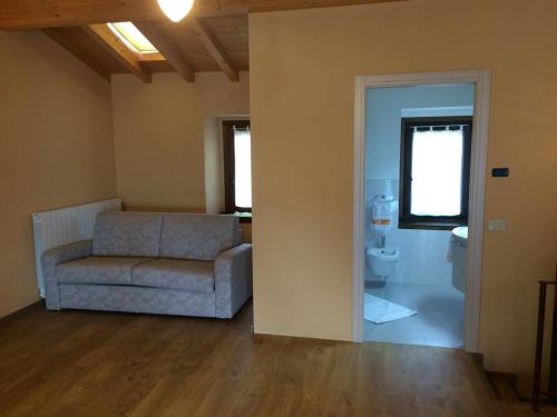 ein Wohnzimmer mit einem Sofa und einem WC in der Unterkunft Casa Rosa holiday in Fonteno