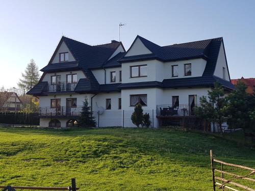 duży biały dom z czarnym dachem w obiekcie U Juhasa Miętówka w mieście Białka Tatrzanska