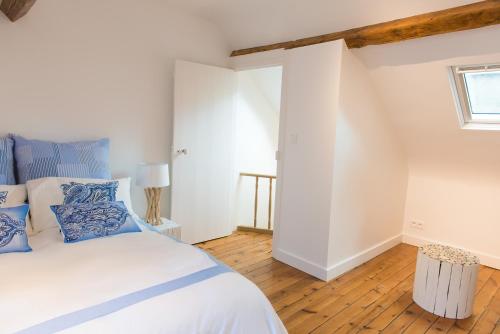 une chambre avec un lit avec des oreillers bleus et blancs dans l'établissement Villa Panama, à Trouville-sur-Mer