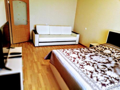 イヴァノヴォにあるПАРИЖСКОЙ КОММУНЫ 41のベッドとソファが備わる部屋