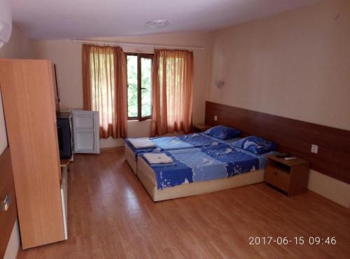 a bedroom with a bed and a television in it at Вили Бийчхаус in Kranevo