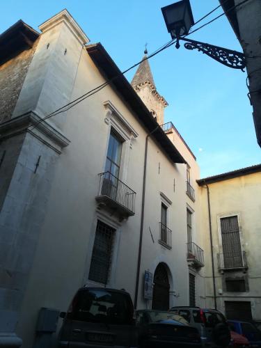 a white building with a tower on a street at Il viandante in Sulmona