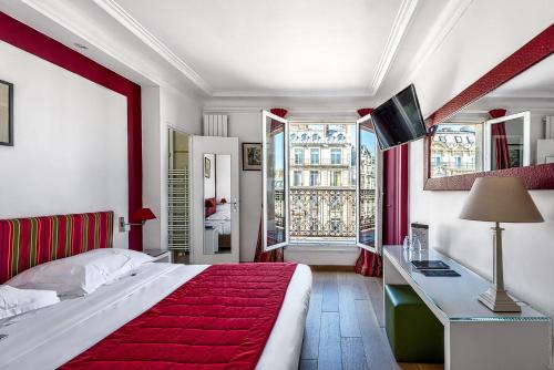 a bedroom with a large bed with a red blanket at Etoile Park Hotel in Paris