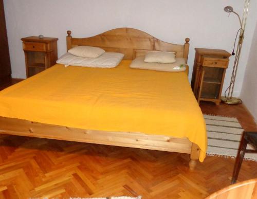 ポロスローにあるDízel Vendégházのベッドルーム1室(木製ベッド1台、黄色い毛布付)