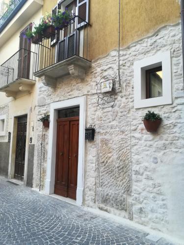 a stone building with a brown door and a balcony at Il viandante in Sulmona