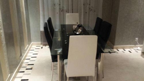 een zwarte eettafel met witte stoelen bij prestigia in Marrakesh