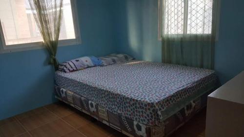 1 dormitorio azul con 1 cama en una habitación en Honeybee apartments, en Bantayan Island
