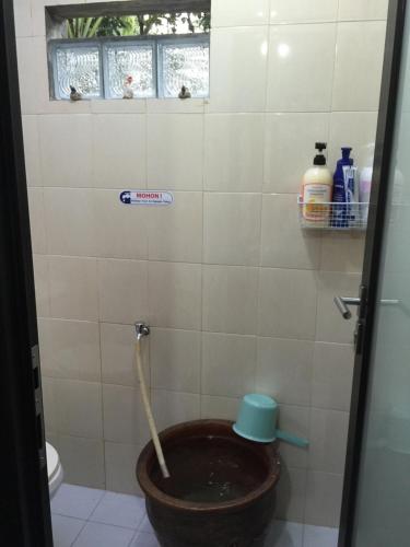 a bathroom with a toilet with a pipe in it at Villa Diantie in Bogor