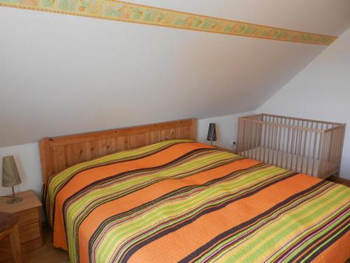 een slaapkamer met een bed met een gestreept dekbed bij Ferienhaus Seehund in Krummhörn