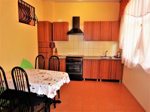 a kitchen with a table and a kitchen with a table and chairs at Golubaya Laguna Guest House in Adler