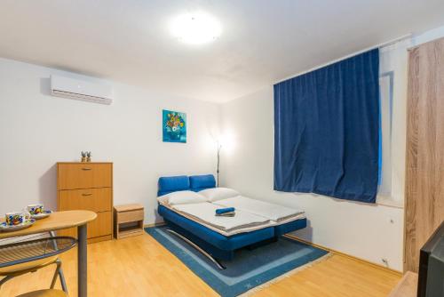 a small room with a bed and a table at Sun studio apartman in Zadar
