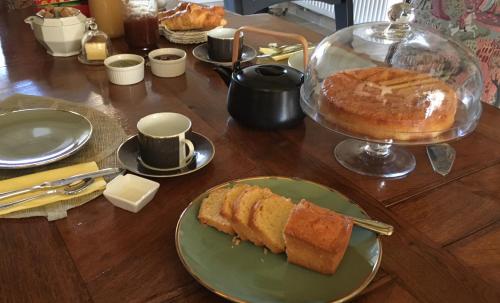 uma mesa com um prato de pão e um bolo em Au Bord de La Dhuy em Orges