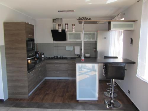 a kitchen with stainless steel appliances and a black counter top at Konrado in Dziwnów