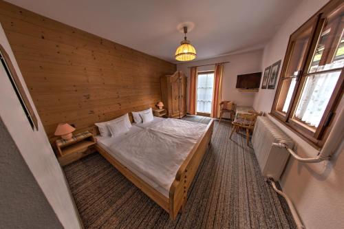 a bedroom with a bed in a wooden wall at Wirtshaus und Pension Hocheck in Ramsau