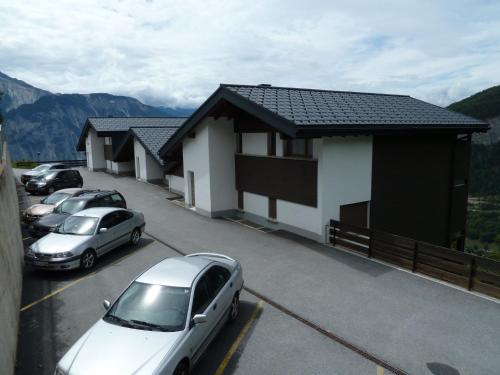 a parking lot with cars parked in front of a house at Haus Stadel Wohnung Nr. 36 in Albinen