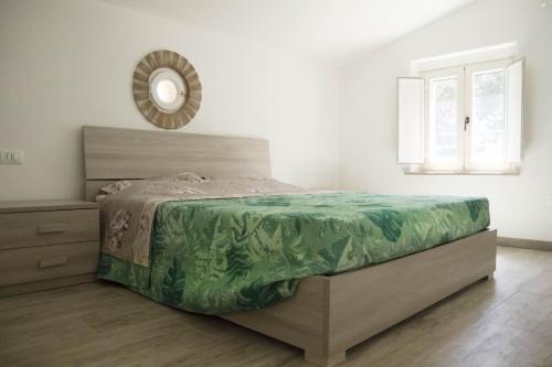 - une chambre avec un lit et un miroir mural dans l'établissement Casina Miriano, à Castiglione del Lago