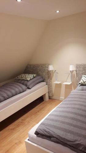 a bedroom with two beds and two lamps at De Friesenjung Nordsee in Risum-Lindholm