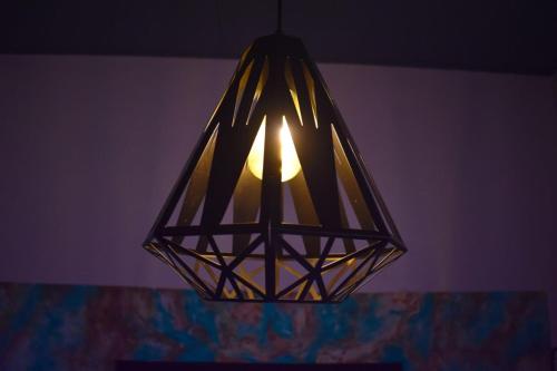 eine Lampe, die von der Decke eines Zimmers hängt in der Unterkunft Hostal Sole in Santa Ana