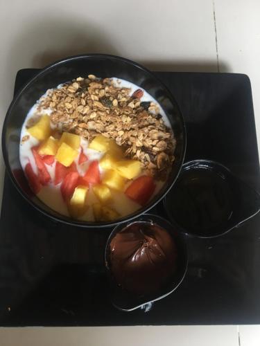 a bowl of food with fruit and chocolate on a table at Los Hermanos Beach Hostal in Guachaca