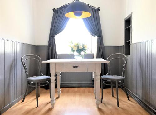 a dining room table with two chairs and a window at Apartments Mauritiushof Weingut FJ Gritsch in Spitz