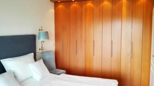 a bedroom with a large wooden cabinet next to a bed at Schloss am Meer Sylt in Wenningstedt