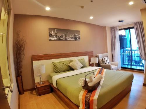 a bedroom with a bed with a doll on it at Astra Suites Night Bazaar in Chiang Mai