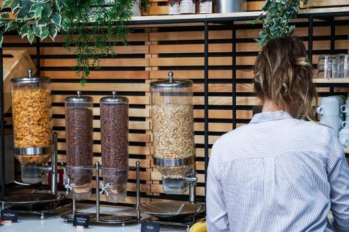 a woman standing in front of a counter with four containers of food at Ibis Girona in Girona