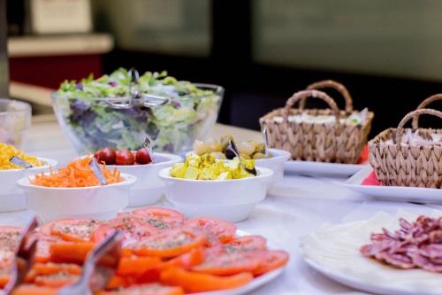 a table topped with bowls of different types of food at Ibis Girona in Girona