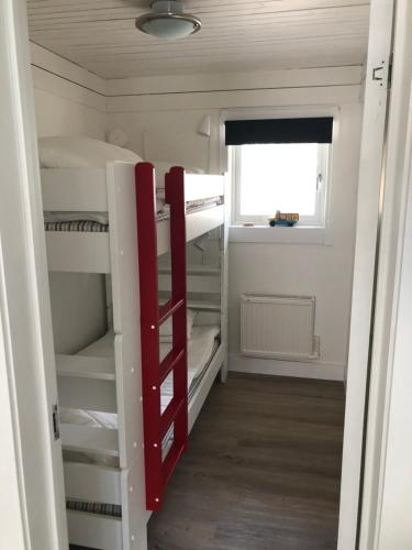 a room with two bunk beds and a window at Hällestrand Cottage -Sillen in Strömstad