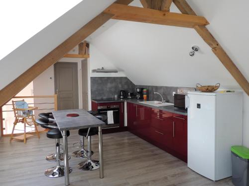a kitchen with red cabinets and a white refrigerator at le petit Vauquelin in Sommervieu