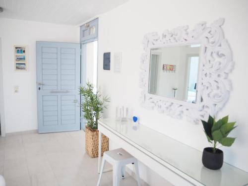 a white bathroom with a mirror and a sink at Kea Villa Thea- Villa Ilios in Vourkarion
