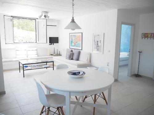 a white living room with a white table and chairs at Kea Villa Thea- Villa Ilios in Vourkarion